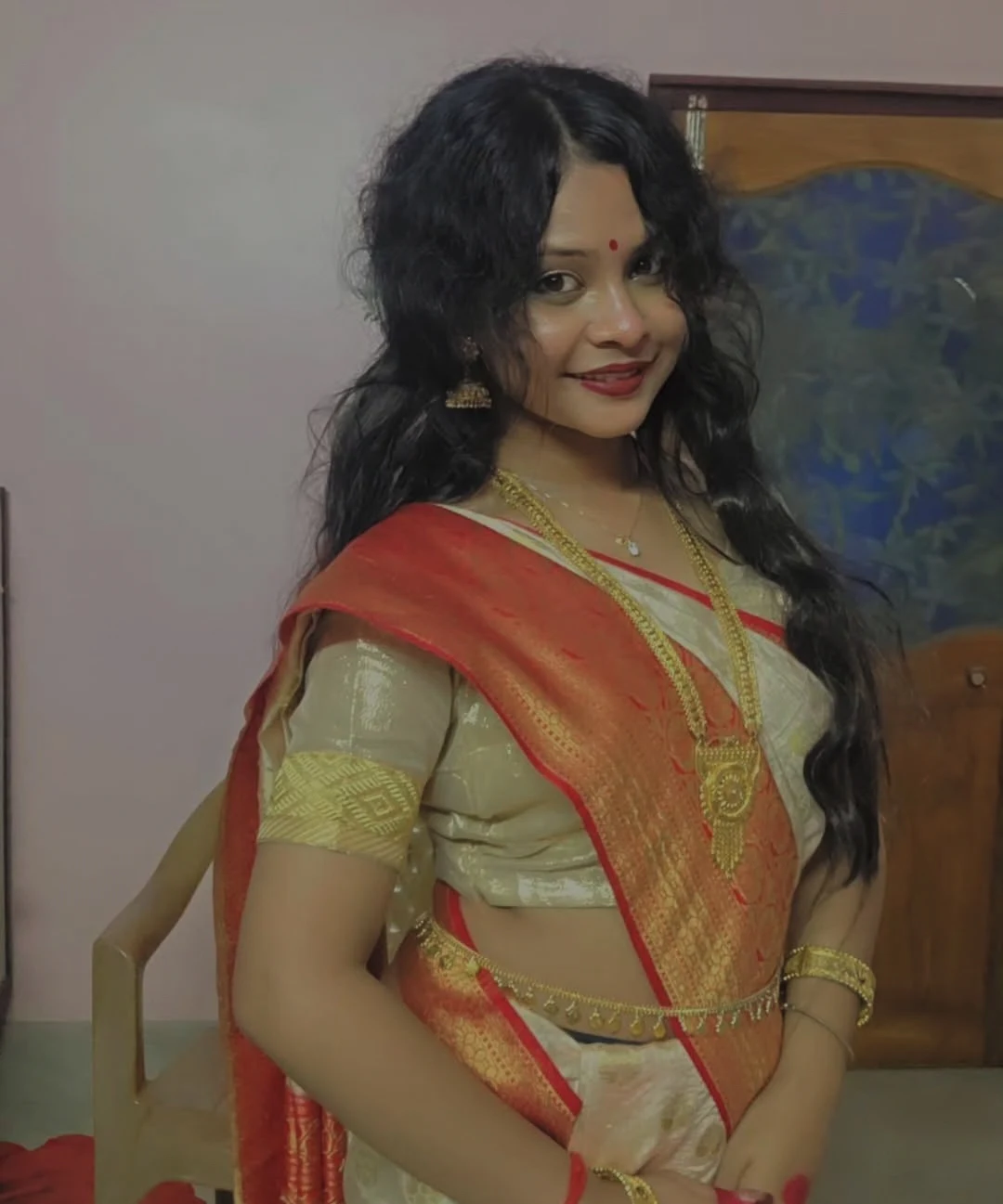 Swarnali in a cream and red sari
